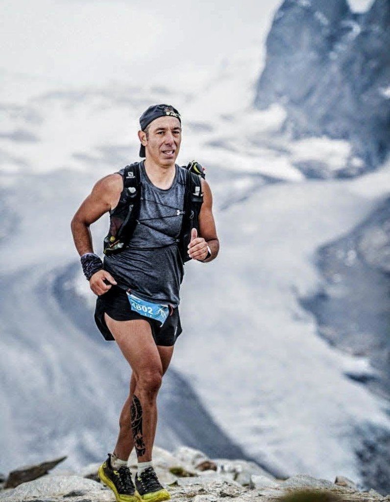 Giovanni Singarella en course de trail en haute montagne, glacier et sommets en arrière-plan